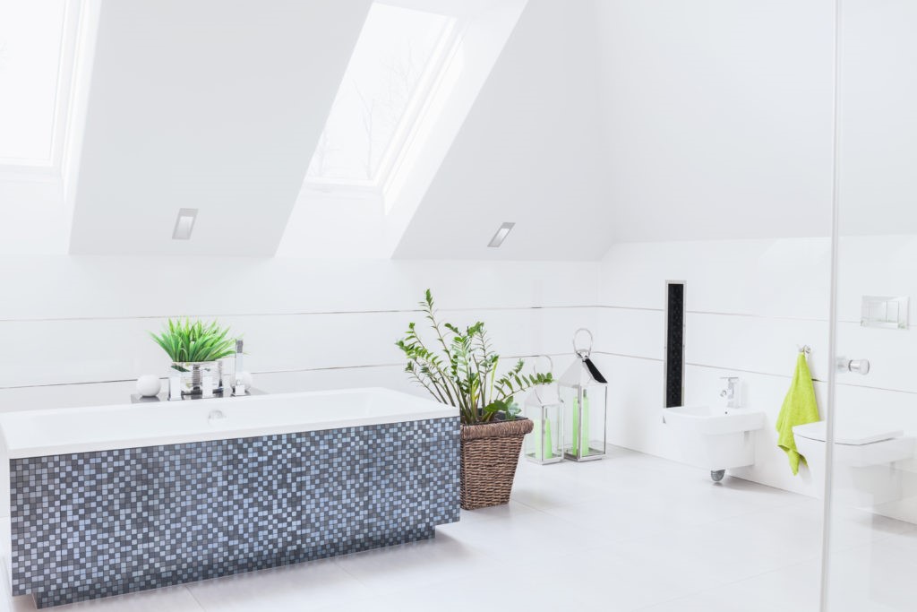 witte badkamer, bad betegeld met blauwe mozaïek
